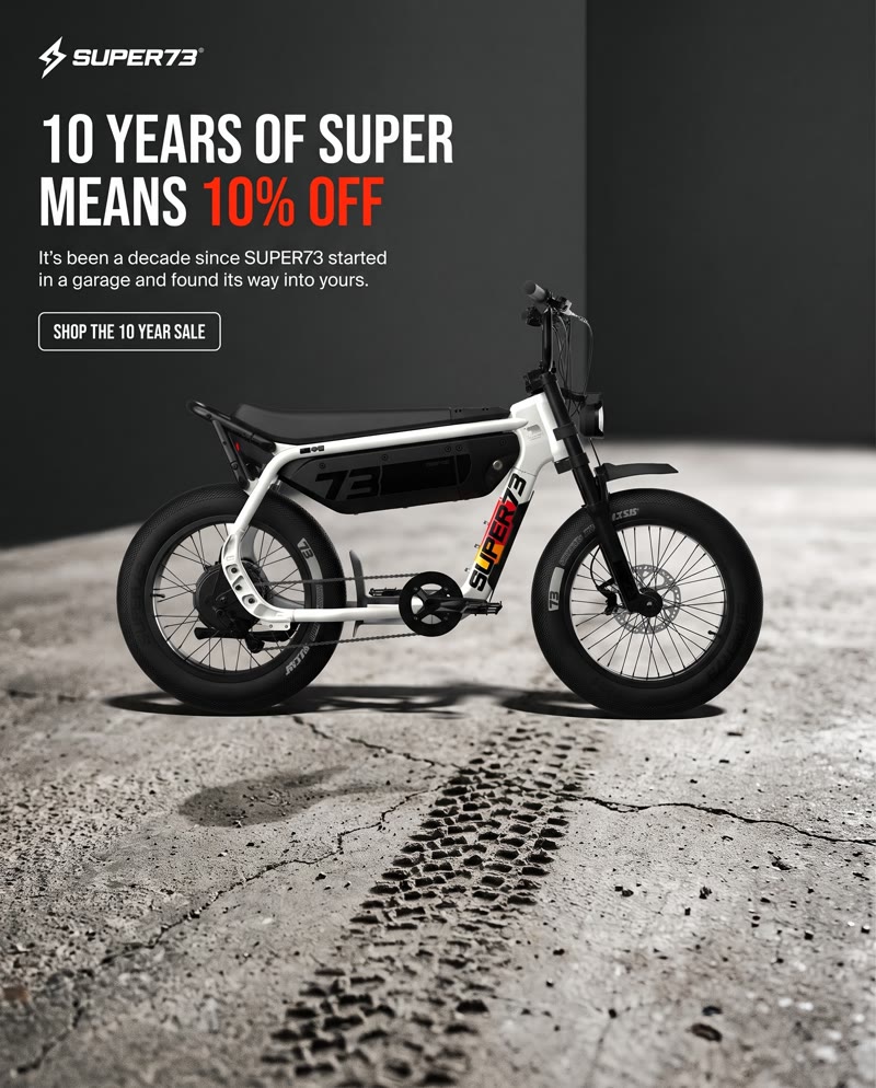 SUPER73 ad: the white bike on wet concrete with tire tracks and the headline "10 years of SUPER means 10% off"