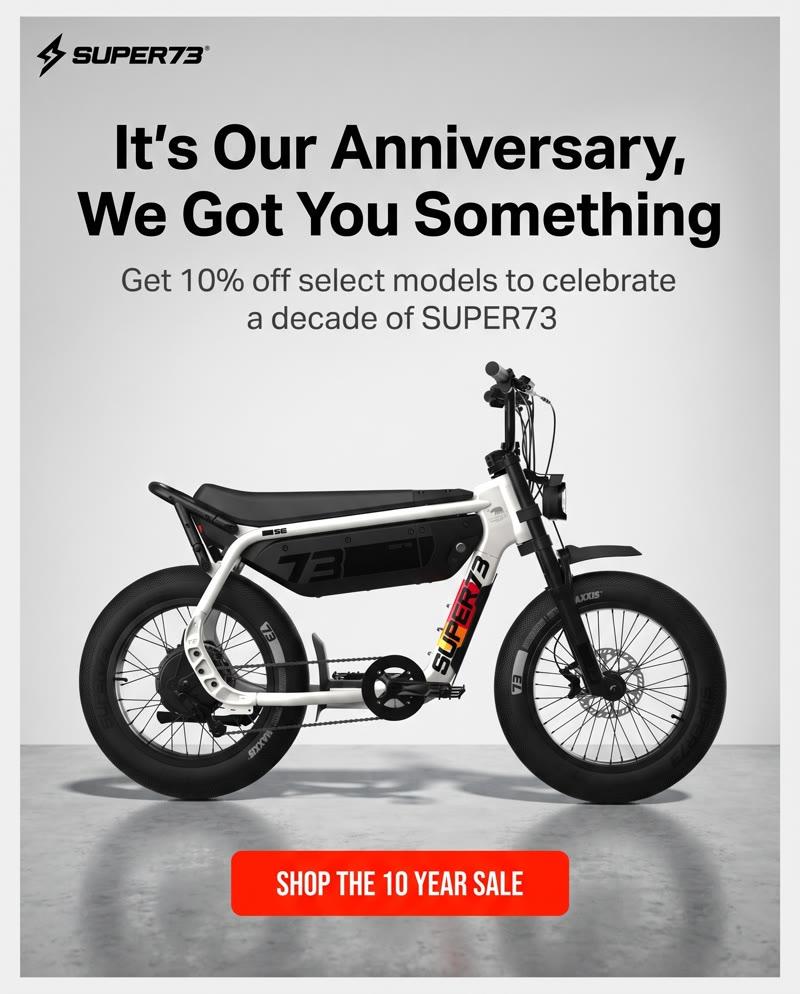 SUPER73 ad: the headline "It's Our Anniversary, We Got You Something", 10% off select models, and the bike on a light grey floor